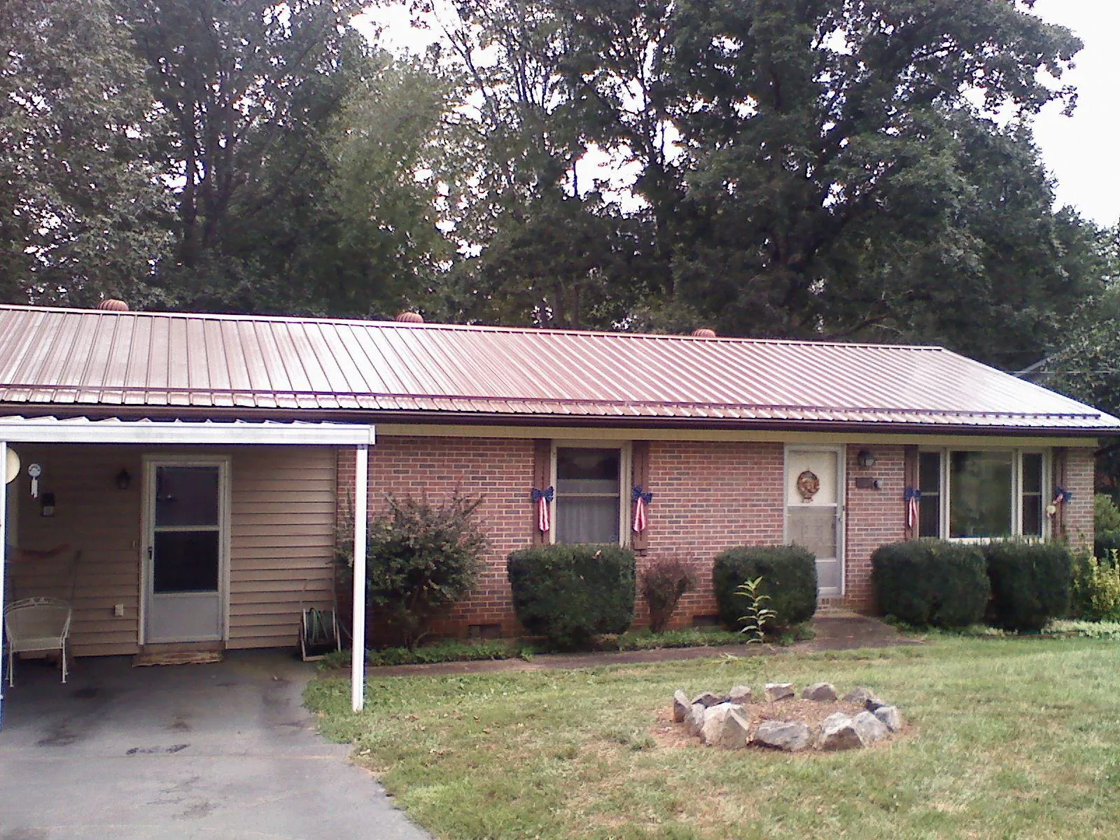 Bronze metal roof and carport on a brick ranch home — Roof Repair work by our crew in Delta City